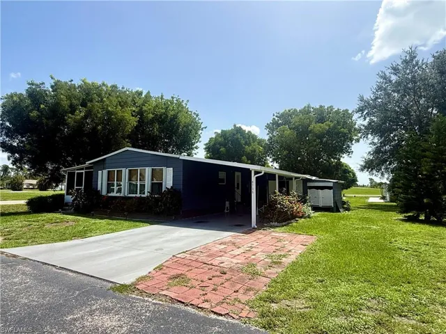 Single-story residential structure with dark blue siding, white window trim, and white shutters