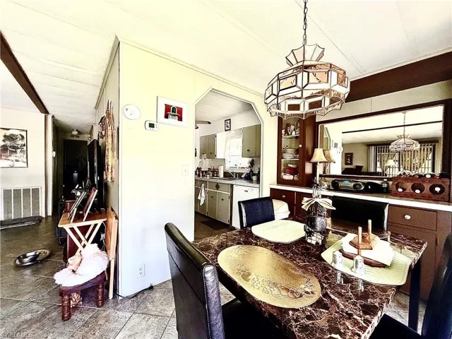 Dining area featuring a marble-finish table, a decorative chandelier, and a built-in buffet with upper display cabinetry