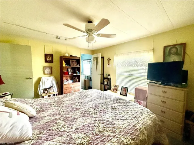 Interior room featuring a ceiling fan, a window with horizontal blinds, and a built-in shelf unit
