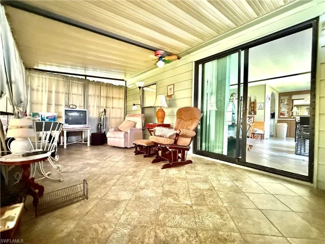 Spacious screened porch featuring a tiled floor, paneled ceiling, and direct access to interior spaces via sliding glass doors