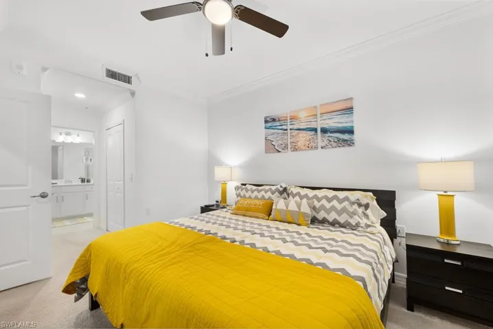 Bedroom with light carpet, crown molding, a closet, and ceiling fan