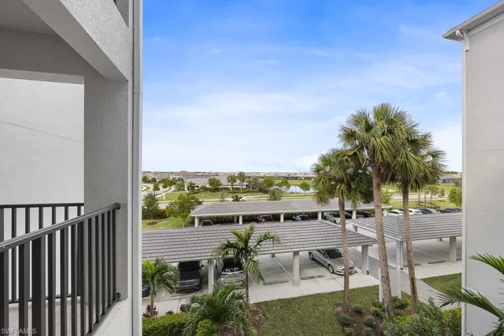 Balcony featuring the parking lot and covered parking spaces