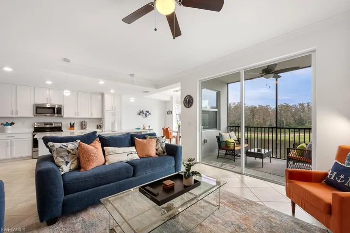 Living room with light tile patterned floors, recessed lighting, a ceiling fan, and ornamental molding