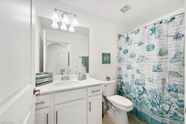 Bathroom featuring vanity, a shower with curtain, and light tile patterned flooring