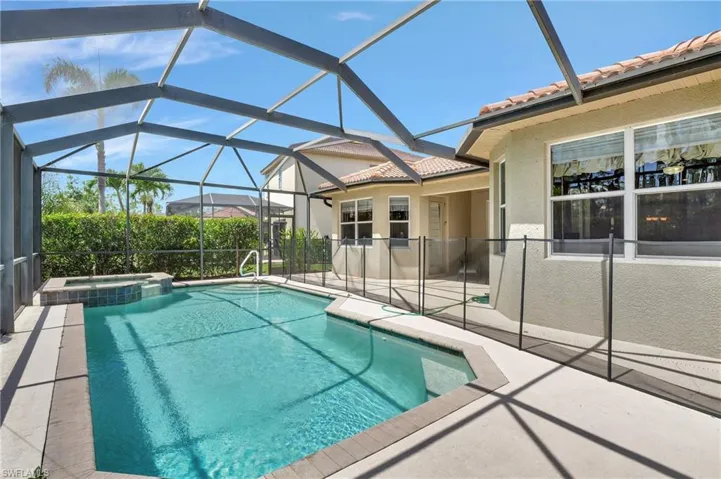View of pool featuring an in ground hot tub, a patio, and glass enclosure
