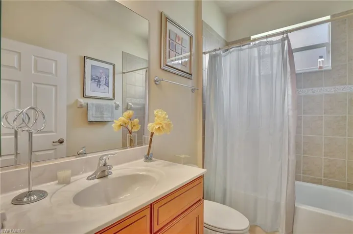 Full bathroom featuring vanity, toilet, and shower / bath combination with curtain