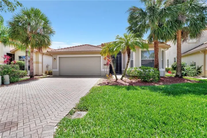 View of front of property featuring a garage and a front lawn