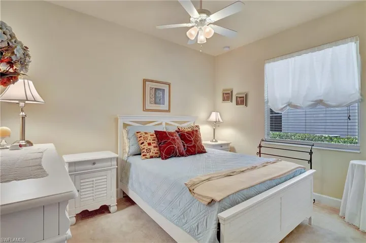 Carpeted bedroom featuring ceiling fan