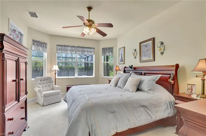 Bedroom with ceiling fan and light colored carpet