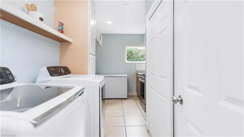 Laundry room featuring light tile patterned floors and independent washer and dryer