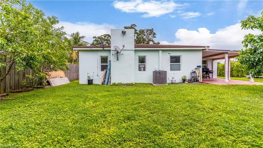 Back of house featuring central AC, a patio, and a lawn