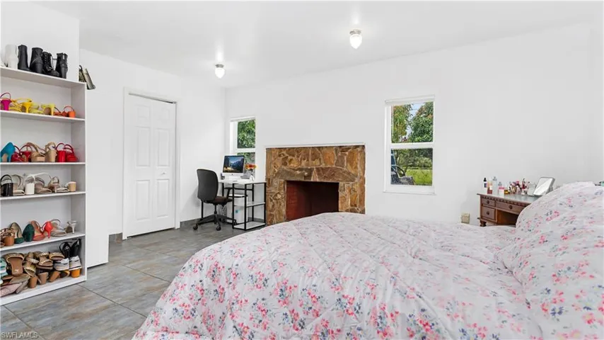Tiled bedroom with a fireplace and multiple windows