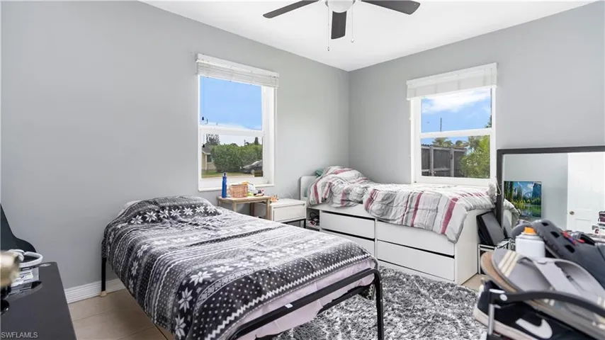 Bedroom with ceiling fan and light tile patterned floors