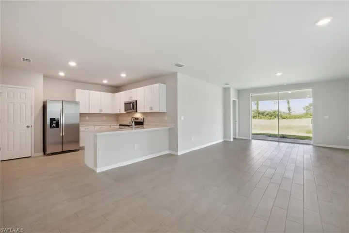 Kitchen featuring appliances with stainless steel finishes, white cabinetry, and kitchen peninsula