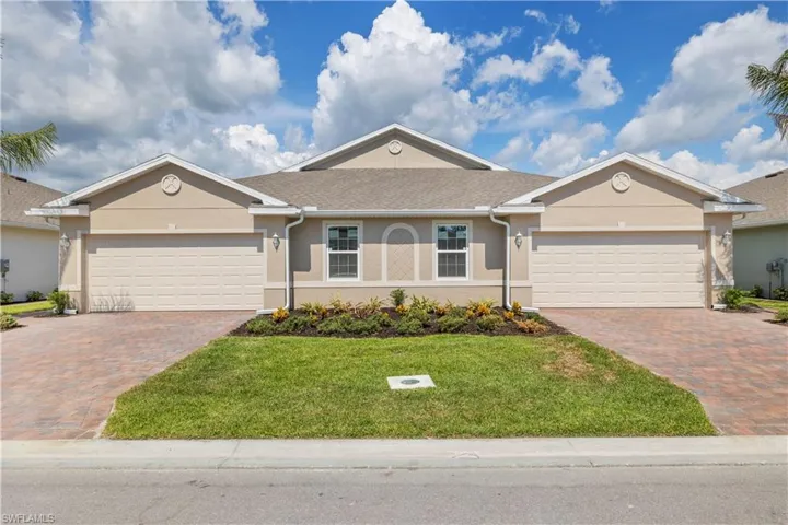 Single story home with a garage and a front lawn