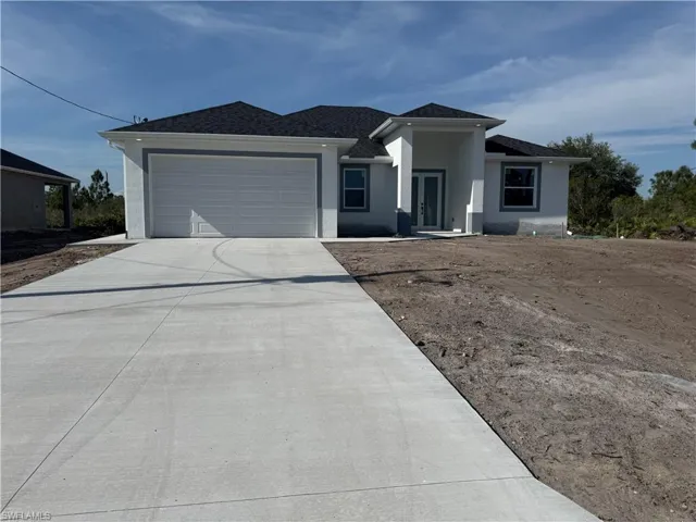 View of front of house with a garage, stucco siding, and concrete driveway