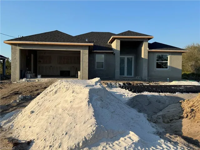 View of front of home with a garage, a shingled roof, french doors, and stucco siding