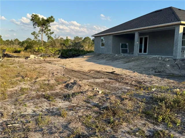 Back of property with roof with shingles and stucco siding