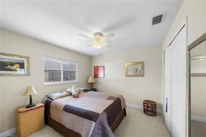 Carpeted bedroom featuring a closet, baseboards, and ceiling fan