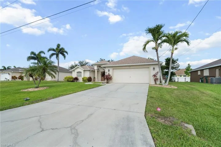 Single story home with driveway, central air condition unit, stucco siding, and an attached garage