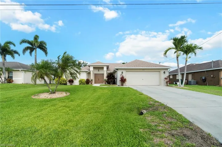 Single story home with concrete driveway, stucco siding, a garage, and a front yard