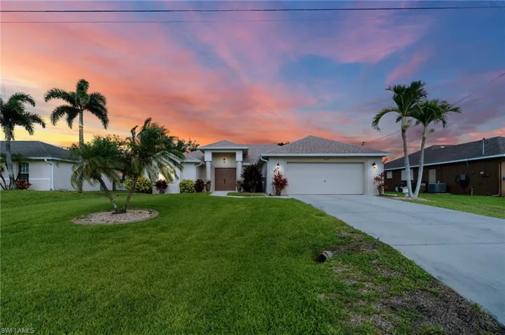 Ranch-style home featuring driveway, an attached garage, stucco siding, a yard, and central air condition unit
