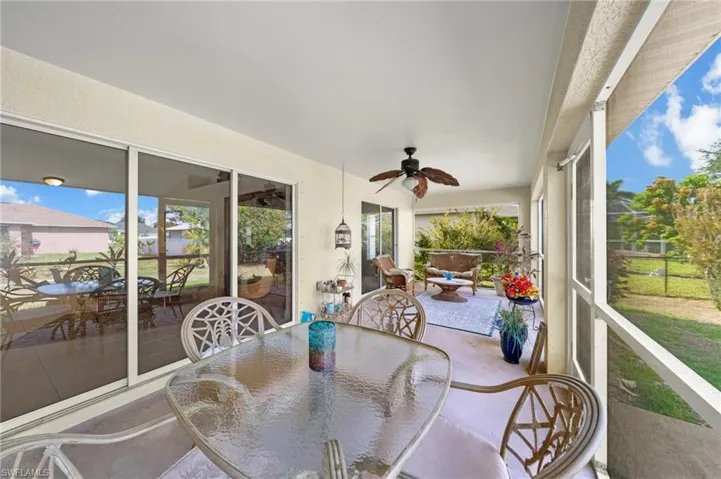 Sunroom / solarium with outdoor dining space and ceiling fan