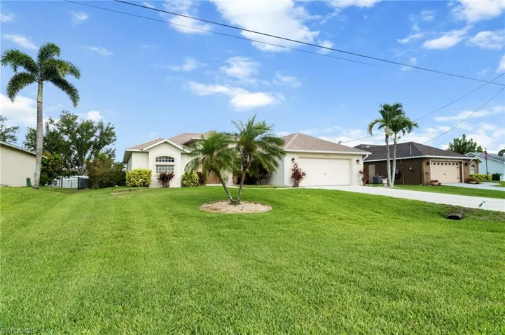 Single story home featuring concrete driveway, a garage, a front lawn, and stucco siding