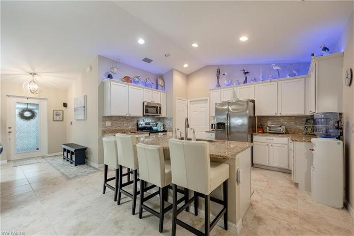 Custom Kitchen with upgrades that include granite countertops, modern light backsplash, soft close white cabinetry, crown molding, stainless steel appliances, additional lighting, island, and pantry.