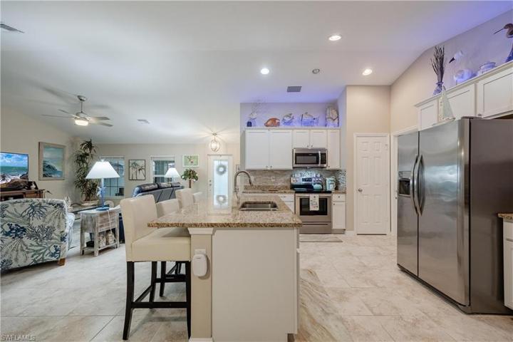 Custom Kitchen with upgrades that include granite countertops, modern light backsplash, soft close white cabinetry, crown molding, stainless steel appliances, additional lighting, island, and pantry.