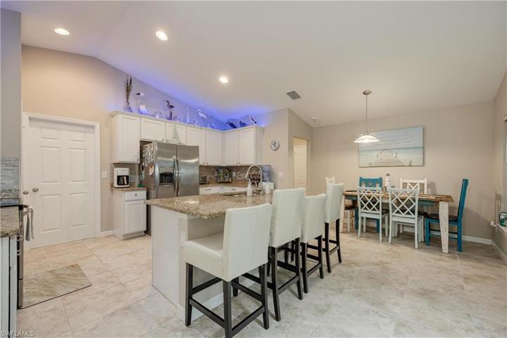 Custom Kitchen with upgrades that include granite countertops, modern light backsplash, soft close white cabinetry, crown molding, stainless steel appliances, additional lighting, island, and pantry.