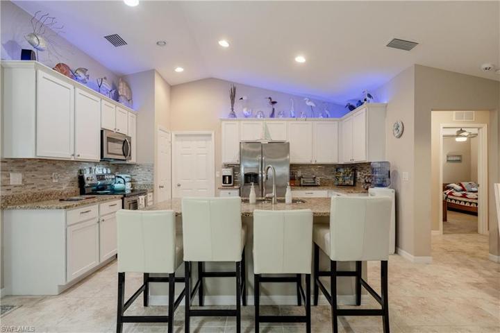 Custom Kitchen with upgrades that include granite countertops, modern light backsplash, soft close white cabinetry, crown molding, stainless steel appliances, additional lighting, island, and pantry.