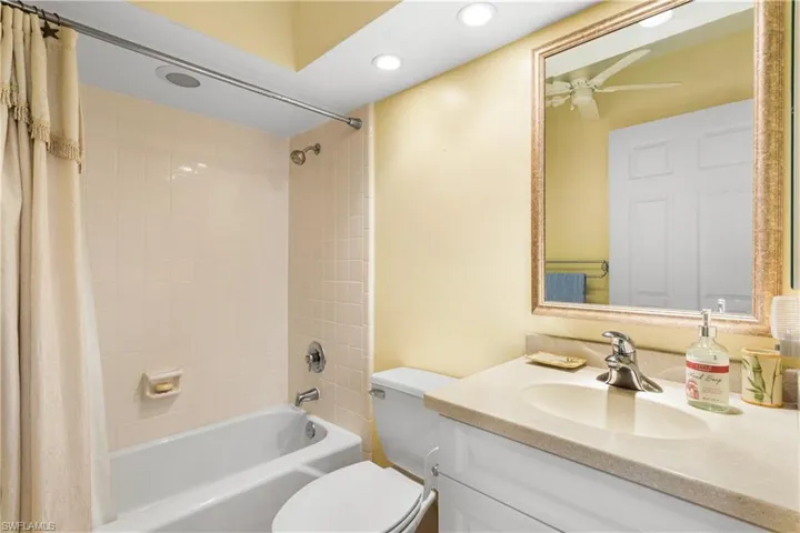 Guest bathroom with updated vanity, recessed lighting, and tub/shower combination.