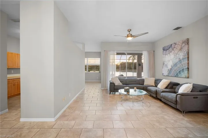 Living room with a ceiling fan and light tile patterned floors