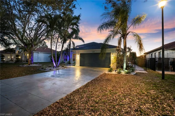 Ranch-style home featuring a garage, concrete driveway, a tile roof, and stucco siding