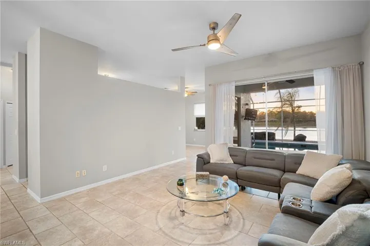 Living area featuring a ceiling fan and baseboards