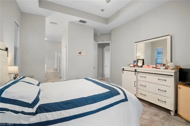 Bedroom with ensuite bathroom, a ceiling fan, and a barn door