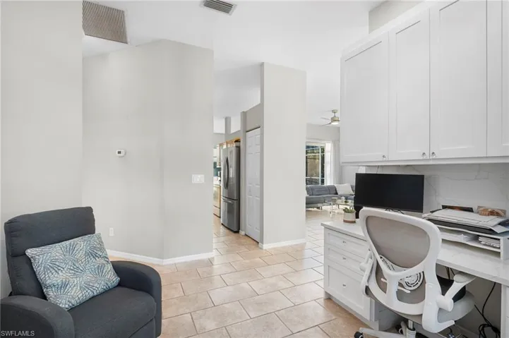 Office area featuring built in desk, ceiling fan, and light tile patterned floors