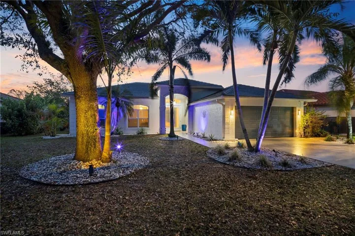 View of front facade with an attached garage, concrete driveway, and stucco siding