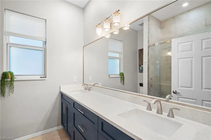 Full bath with double vanity and a stall shower