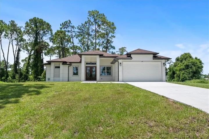 View of front of house featuring a garage and a front lawn