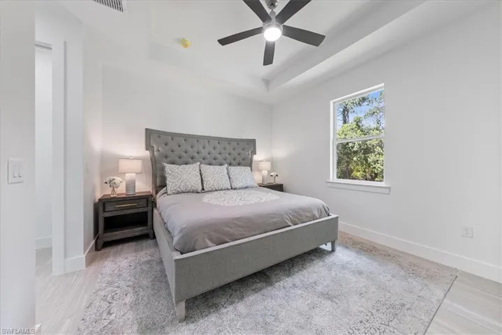Bedroom featuring a raised ceiling and ceiling fan