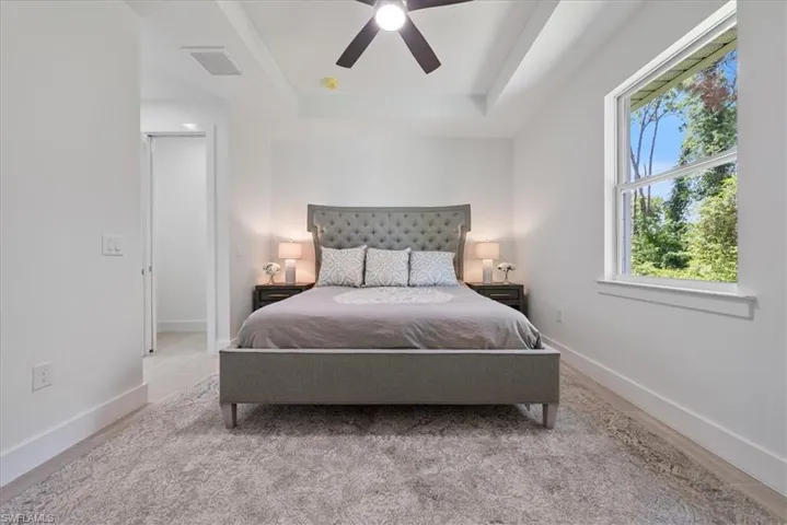Bedroom with a tray ceiling and ceiling fan