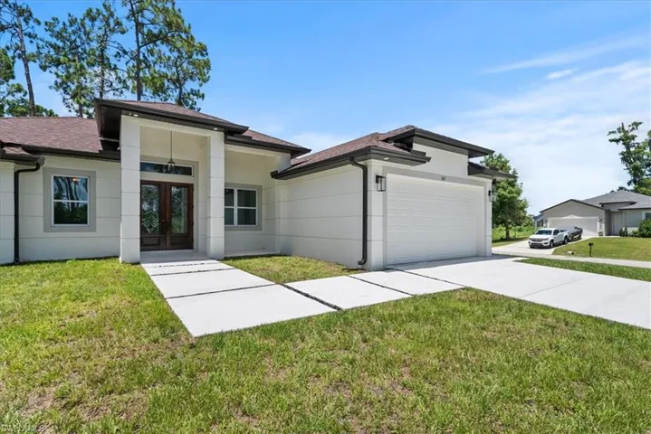 View of front of home with a garage and a front yard