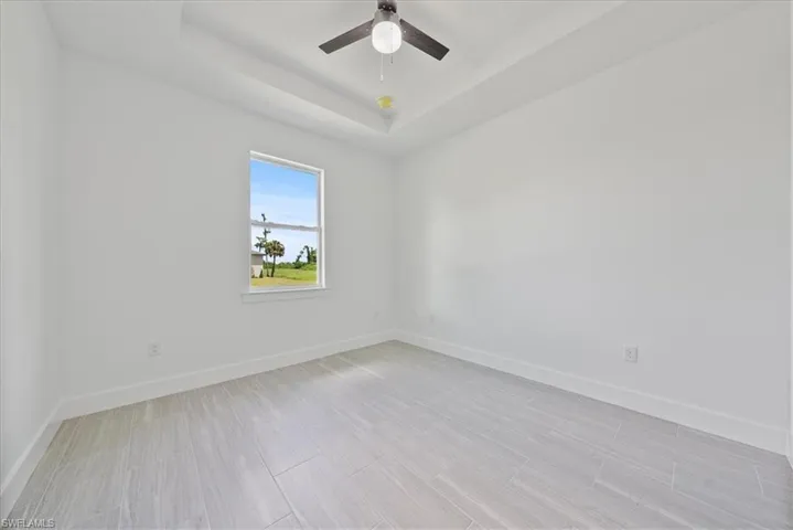 Spare room featuring ceiling fan and a tray ceiling