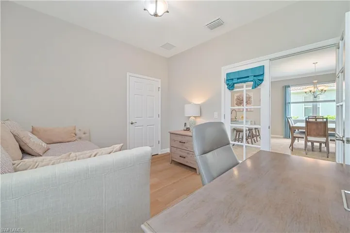 Bedroom with light hardwood / wood-style flooring and an inviting chandelier