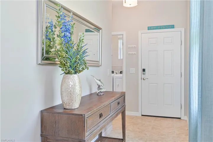 Entrance foyer with washer and clothes dryer and light tile patterned floors