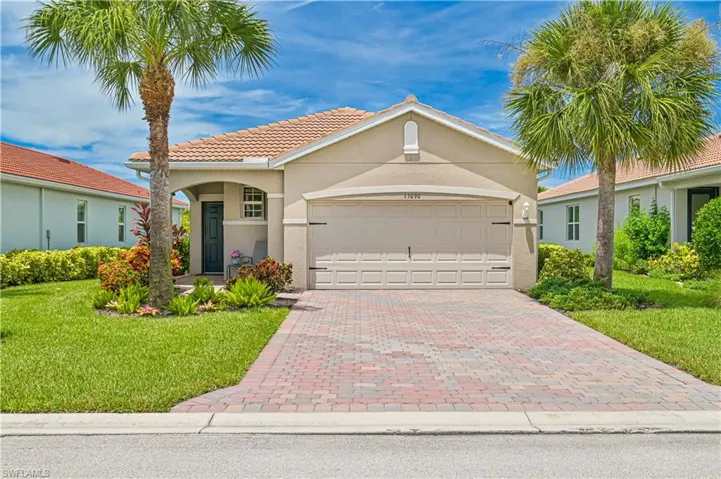 View of front of house with a garage and a front lawn