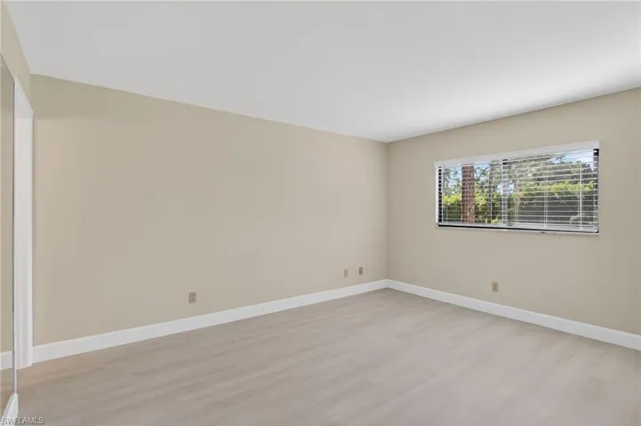 Spare room with light vinyl-style floors and baseboards