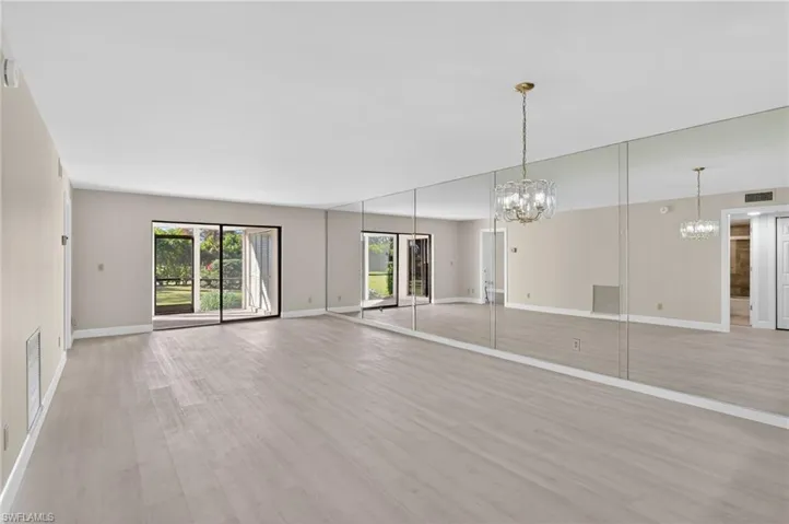 Mirrored living/dining room featuring hanging lights and light vinyl-type flooring